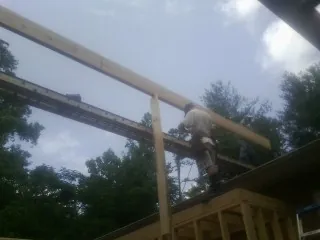 Carpenter setting a ridge beam over a new addition frame — Ice Dam Removal by Roofing Brothers in West Eaton