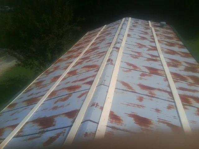 Rusted metal roof panels with new wood purlins before replacement — Storm Damage Roof Repair in West Eaton by Roofing Brothers